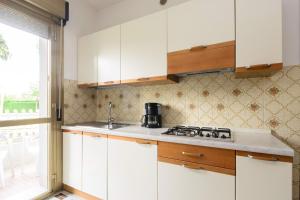 a kitchen with white cabinets and a stove at Apartment in Lignano 21638 in Lignano Sabbiadoro