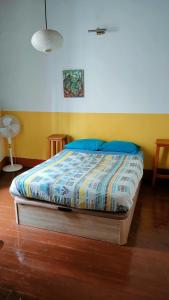 a bedroom with a bed with blue pillows at Hostel Albergue La Casa Encantada in El Paso