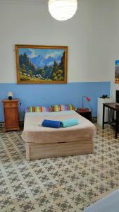 1 dormitorio con 1 cama con una pintura en la pared en Hostel Albergue La Casa Encantada, en El Paso