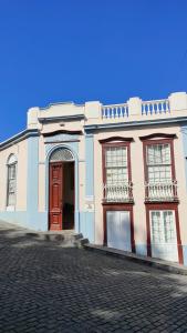 a building with a red door on a street at Hostel Albergue La Casa Encantada in El Paso