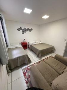a room with two beds and a couch in it at Social Hostel Café e Bar in Curitiba