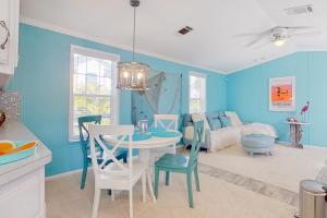 uma cozinha e sala de estar com paredes azuis e uma mesa e cadeiras em The Blue Bayou em Naples