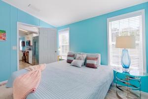 um quarto com paredes azuis e uma cama com uma mesa de vidro em The Blue Bayou em Naples