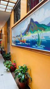 a large painting on a wall with potted plants at HOTEL El INDIO in Otavalo