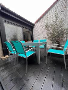 um pátio com uma mesa e cadeiras num deque em Villa du parc au cœur de Malo em Dunkerque