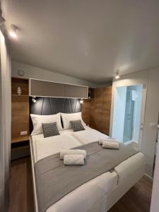 1 dormitorio con 1 cama grande y 2 almohadas en Mobile Homes MaLu, en Biograd na Moru