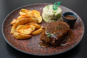 瓜鲁柳斯Slaviero Guarulhos Aeroporto的盘子,包括肉、土豆和酱料