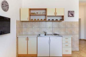 een keuken met witte kasten en een wastafel bij One-Bedroom Apartment Crikvenica near Sea 3 in Crikvenica