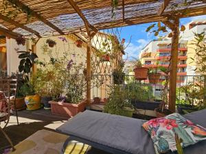 a patio with potted plants and a pergola at Villa la clémente in Menton