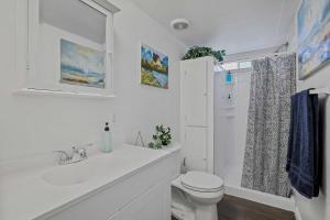 a white bathroom with a toilet and a sink at Boat and Fish on Lewisville Lake Pet-Friendly Haven in Lake Dallas +16 photos