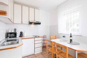 One-Bedroom Apartment in Crikvenica I في دْرامالج: مطبخ مع حوض وطاولة مع كراسي
