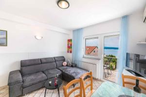 a living room with a couch and a table at One-Bedroom Apartment in Crikvenica XI in Dramalj