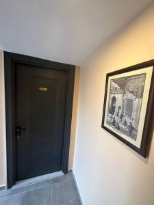 eine schwarze Tür in einem Raum mit einem Bild in der Unterkunft Hanedan Hotel in Istanbul