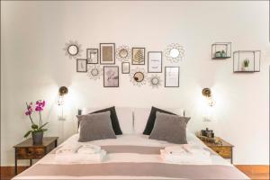 a bedroom with a white bed with pictures on the wall at Khris Home Apartments - Trastevere Crisogono in Rome