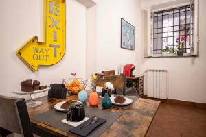 a dining room table with a way out sign on the wall at Khris Home Apartments - Trastevere Crisogono in Rome
