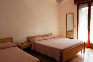 a bedroom with two beds and a window at Residence Milena in Milano Marittima