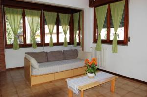ein Sofa im Wohnzimmer mit Fenstern in der Unterkunft Residence Milena in Milano Marittima