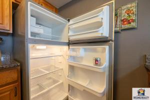an empty refrigerator with its door open in a kitchen at 2BR Walk-In Condo - Near the 76 Strip - Pool - FREE TICKETS INCLUDED - CLA-8 in Branson