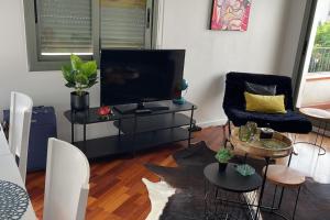 a living room with a flat screen tv and a couch at Pure Bliss Apartment Sitges in Sitges