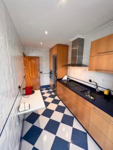 een keuken met een zwart-wit geruite vloer bij Apartamento nuevo en el centro de Ourense 1 in Ourense