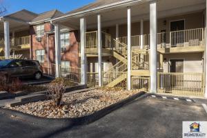 a building with balconies and a car in a parking lot at 2BR Walk-In Condo - Near the 76 Strip - Pool - FREE TICKETS INCLUDED - CLA-8 in Branson