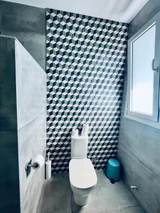 La salle de bains est pourvue de toilettes et d'un mur en damier. dans l'établissement The Blue House, à Larnaka