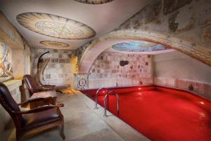 於爾居普的住宿－Capp Royal Cave HOTEL，一个带椅子的房间,一个大型红色游泳池