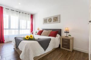 Un dormitorio con una cama con flores. en Playa Victoria Paseo Marítimo 3 Rooms en Cádiz