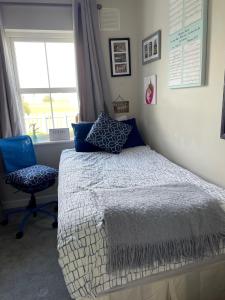 a bedroom with a bed and a chair and a window at Rosslare Wexford in Saint Helens