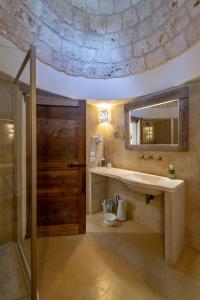 a bathroom with a sink and a mirror and a shower at Agriturismo Masseria Aprile in Locorotondo