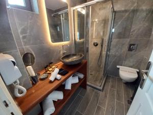 a bathroom with a sink and a toilet and a shower at En Plo Boutique Suites in Oia