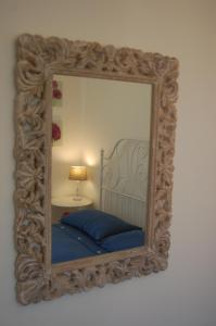 a mirror with a bed and a lamp in a room at Appartamento Giovanni in Lido Adriano