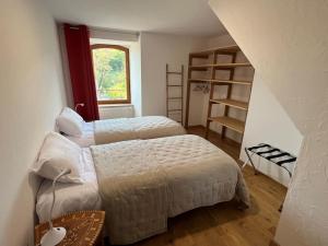 1 Schlafzimmer mit 2 Betten und einem Fenster in der Unterkunft Les Distinguées -Aux Bories de Prévinquières in Recoules-Prévinquières