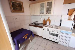 a small kitchen with a stove and a table in it at Apartment in Dramalj 5752 in Dramalj