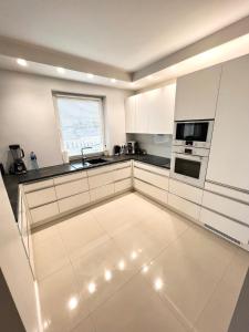 a large kitchen with white cabinets and a window at Spanko w centrum in Zielona Góra