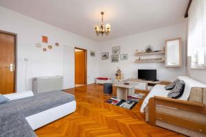 a living room with two beds and a television at Apartment in Crikvenica 5224 in Dramalj