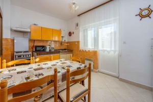 a kitchen with a table and chairs and a table and a kitchen at Apartment in Crikvenica 5224 in Dramalj