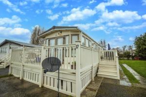 a large white house with a gate at 6 Berth Caravan With Decking At Manor Park In Hunstanton Ref 23017h in Hunstanton