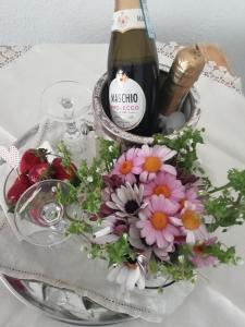 - une bouteille de vin et des fleurs sur une table dans l'établissement La Fusarella Villa Santoro, à Vico Equense