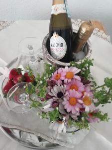 a bottle of wine and flowers on a table at La Fusarella Villa Santoro in Vico Equense
