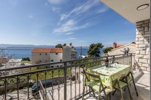 a balcony with a table and a view of the water at Apartments Petra in Bol