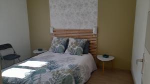 - une chambre avec un lit et une tête de lit en bois dans l'établissement Evasion45, à Étauliers
