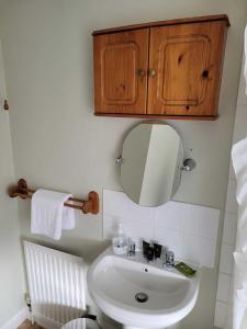 a bathroom with a sink and a mirror at Ratcliffe House - Spacious 3 bedroom House in Sileby in Sileby