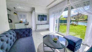 a living room with a blue couch and a glass table at House De Luxe in Bihać