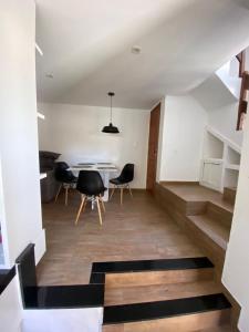 a room with stairs and a table and chairs at Casa triplex com cobertura a 5 minutos da praia in Arraial do Cabo