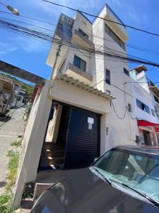 a car parked in front of a house with a garage at Casa triplex com cobertura a 5 minutos da praia in Arraial do Cabo