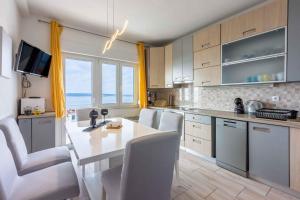 een keuken met een tafel en stoelen en een aanrecht bij Apartment in Crikvenica 39213 in Crikvenica