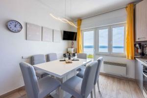 een eetkamer met een tafel en stoelen en een klok bij Apartment in Crikvenica 39213 in Crikvenica