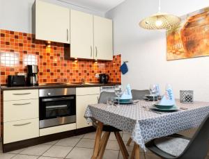 a kitchen with a table with chairs and a tablecloth on it at Gollwitzer Park Sturmvogel in Gollwitz