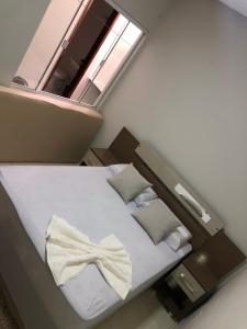 a small bedroom with a bed with a window at Flat Hotel in Guanamby